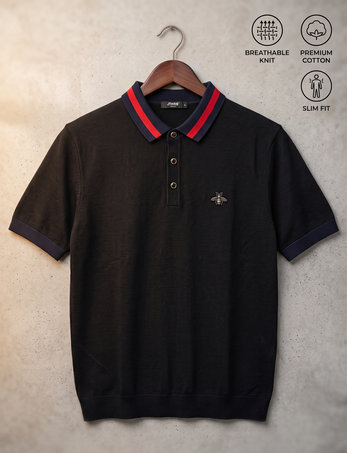 A black short-sleeve polo shirt with a red and navy blue striped collar, hanging on a wooden hanger against a textured gray wall. The shirt features a small embroidered bee logo on the left chest and includes three text callouts in the upper right: 'BREATHABLE KNIT', 'PREMIUM COTTON', and 'SLIM FIT'.