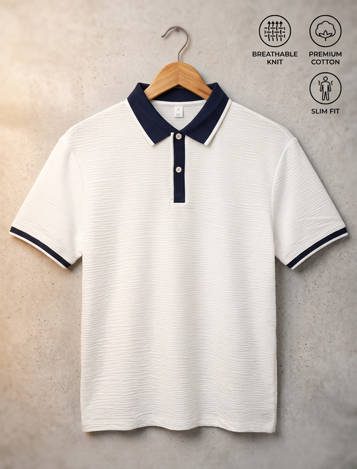A white short-sleeve polo shirt with a navy blue collar and sleeve trim, hanging on a wooden hanger against a textured beige wall. Three feature icons are visible on the top right, and a model number and brand name 'JTNRB' are shown at the bottom.