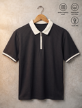 A dark charcoal gray short-sleeve polo shirt with a white collar and white striped cuffs, hanging on a wooden hanger against a textured beige wall. Three feature icons on the top right highlight 'Breathable Knit', 'Premium Cotton', and 'Slim Fit'.