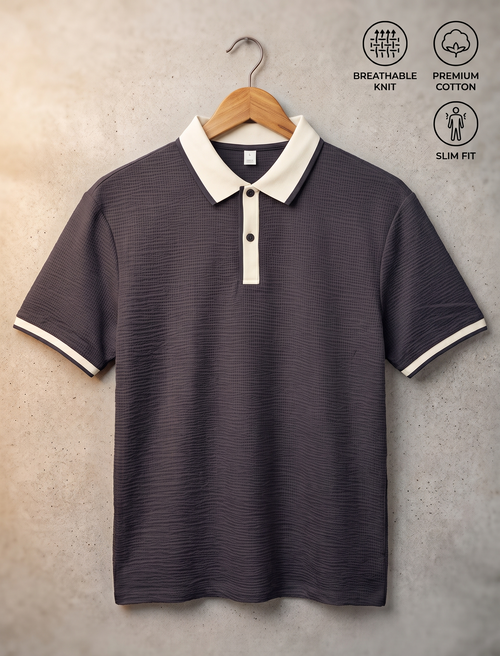 A dark gray short-sleeve polo shirt with a white collar and white sleeve trim, hanging on a wooden hanger against a textured beige wall. Three feature icons on the top right read 'BREATHABLE KNIT', 'PREMIUM COTTON', and 'SLIM FIT'.